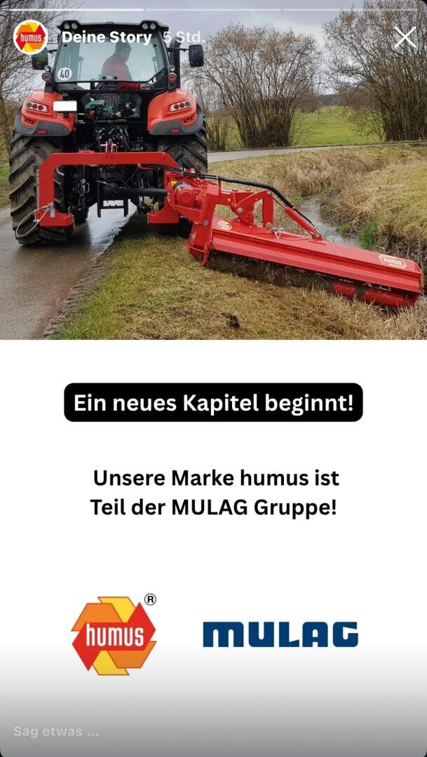 Ein roter Traktor mit einem großen Mähwerk fährt neben einer Landstraße. Der Text darunter verkündet: Unsere Marke humus ist Teil der MULAG Gruppe!", wobei die Logos von humus und MULAG abgebildet sind.