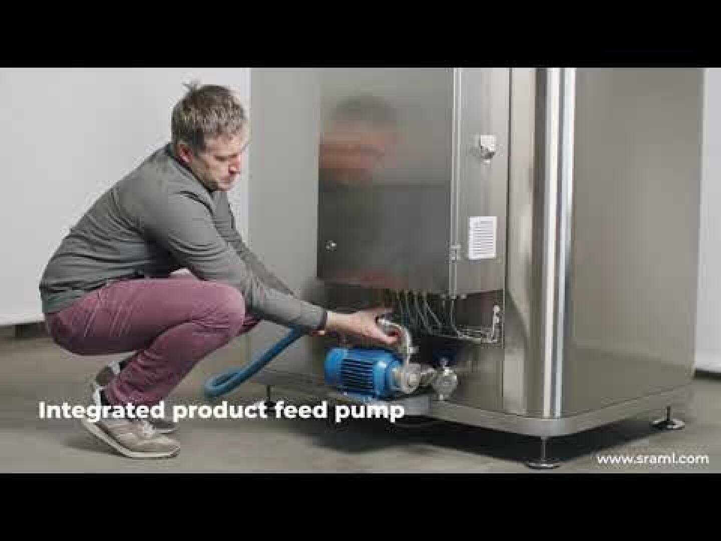 A person kneels next to a stainless steel industrial machine and adjusts a blue integrated product feed pump. The text on the picture reads: "Integrated product feed pump".