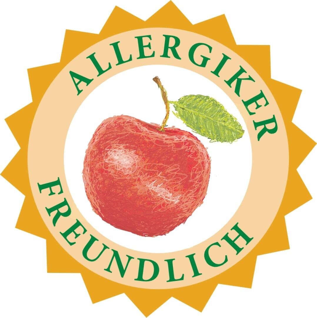 A yellow sunburst badge with a red apple and a green leaf in the center. The German words ALLERGIKER FREUNDLICH circle the apple.