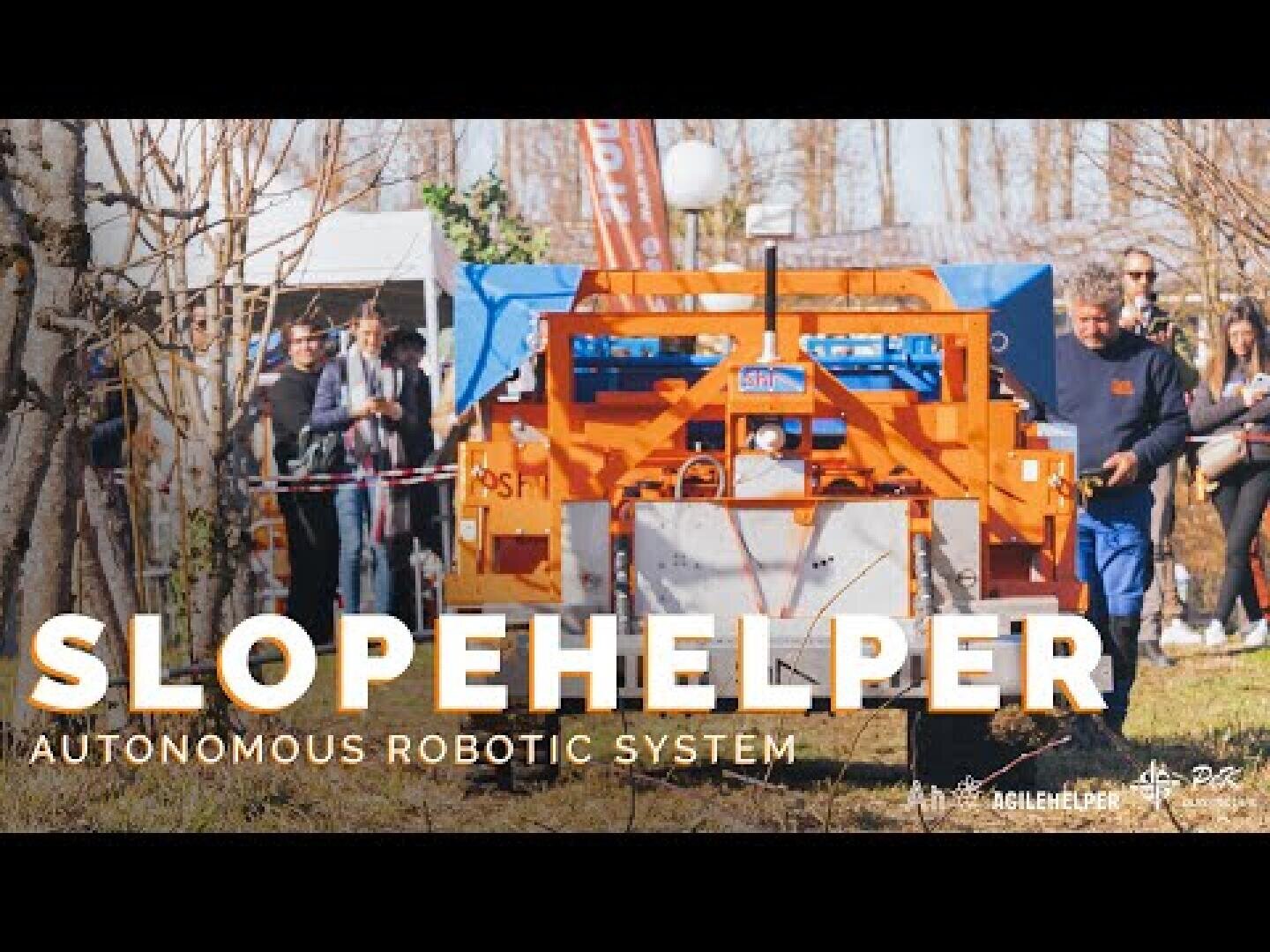 A group of people observe a large orange robotic machine labeled Slopehelper outdoors, with the text Autonomous Robotic System displayed on the image. The machine appears to be used for agricultural purposes.