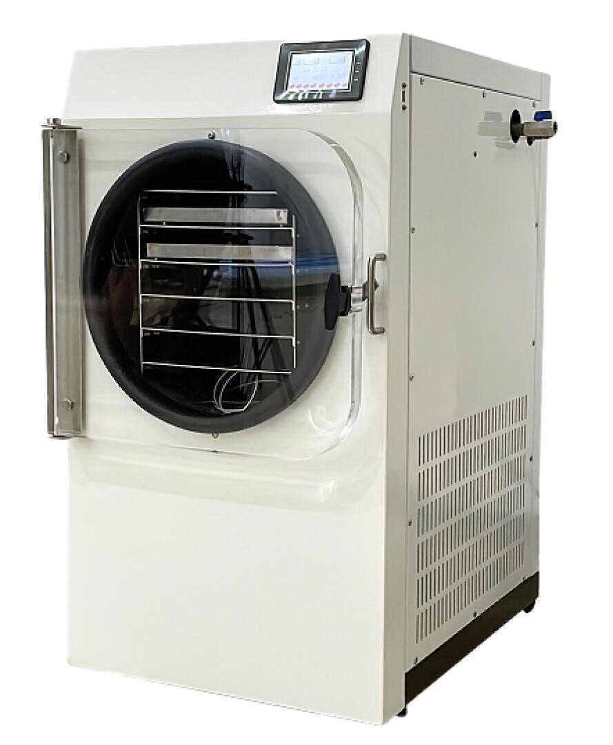 Eine weiße Gefriertrocknungsmaschine mit runder Fronttür, transparentem Fenster, Metallablagen im Inneren und einem digitalen Display auf der oberen Frontplatte.