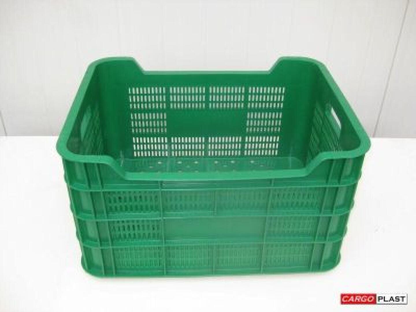 A large green plastic crate with ventilation holes on the sides and base, which stands on a white surface. The crate is empty and has built-in handles for easy carrying.